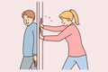 Positive man hides behind door preventing girlfriend from passing or arranging prank