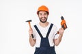 Positive man holding drill and hammer showing rock gesture Royalty Free Stock Photo