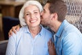 Positive man kissing his grandmother