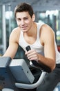 Positive man at legs bicycle exercises machine Royalty Free Stock Photo