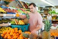 Positive man standing with full shopping cart Royalty Free Stock Photo