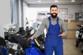 Positive man worker demonstrating motorbikes Royalty Free Stock Photo