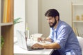 Positive man worker eating healthy balanced meal and working on laptop Royalty Free Stock Photo