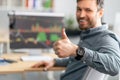 Positive mature businessman working on computer with graphs and charts on screen, showing thumb up, selective focus Royalty Free Stock Photo