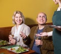 Positive mature couple having dinner at restaurant Royalty Free Stock Photo