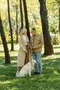 Positive mature couple standing near labrador Royalty Free Stock Photo