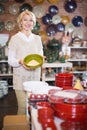 Positive mature female choosing ceramic cookware Royalty Free Stock Photo