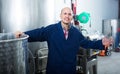 positive mature man working in wine secondary fermentation section Royalty Free Stock Photo