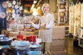 Positive mature woman standing at ceramic section Royalty Free Stock Photo