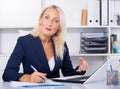 Positive mature woman working in office