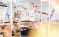 Mature woman practicing pilates stretching exercises on reformer at gym Royalty Free Stock Photo