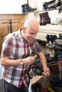 Workman repairing pair of shoes . Royalty Free Stock Photo