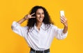 Positive Millennial Lady Taking Selfie On Smartphone And Showing Peace Gesture