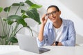 Positive millennial latin lady in glasses at table with computer, enjoy work and study Royalty Free Stock Photo