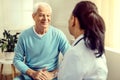 Positive minded elderly man listening to nurse during consultation Royalty Free Stock Photo