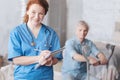 Positive minded medical worker smiling while taking notes Royalty Free Stock Photo