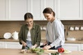 Positive mom and teenage daughter kid cooking in kitchen Royalty Free Stock Photo