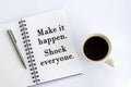 Positive motivational words - Make it happen. Shock everyone. On book page with pen and cup of morning coffee on white background.