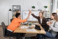 Positive multiracial businesswomen partners giving high five during business meeting at office. Royalty Free Stock Photo
