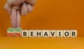 Positive or negative behavior symbol. Businessman turns cubes, changes words negative behavior to positive behavior. Orange