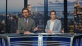 Positive news readers talking live tv newscast in night channel studio closeup Royalty Free Stock Photo