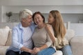 Positive old senior woman hugging mature husband and adult daughter Royalty Free Stock Photo