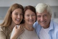 Positive old senior woman hugging mature husband and adult daughter Royalty Free Stock Photo