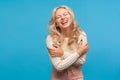 Positive optimistic woman with blond curly hair hysterically laughing enjoying life and freedom, carefree female