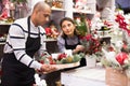 Owner and assistant of a flower shop prepares christmas decorations and arrangements