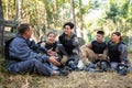 Positive paintball players sitting on battleground and chatting Royalty Free Stock Photo