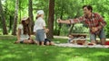 Positive parents blowing soap bubbles with children in park