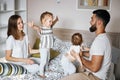 Positive parents and children having fun and jumping on the bed. Royalty Free Stock Photo