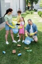 Positive parents with kids collecting trash