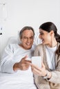 Positive patient pointing at smartphone near