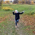 A photo of a smiling little girl running on a path in an autumn park Royalty Free Stock Photo