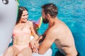 Positive picture of gorgeous couple swimming in pool. Girl is lying on air mattress. They look at each other and smile