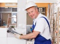 Positive plumber working with plastic pipes Royalty Free Stock Photo