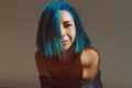 Positive portrait of a girl with blue hair in the sunlight on a wall background Royalty Free Stock Photo