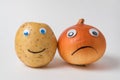 Positive potato and a sad napiform onion with Googly eyes on white background. Pessimist and optimist concept