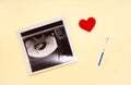 Positive pregnancy test strip and ultrasound image of the fetus, red heart. The concept of conception, waiting for the birth of a Royalty Free Stock Photo