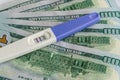 A positive pregnancy test on the US dollars background