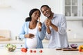Positive pregnant black couple singing while cooking Royalty Free Stock Photo