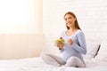 Positive Pregnant Woman Eating Salad Sitting On Bed Indoor Royalty Free Stock Photo