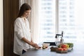 Positive pretty cook blogger girl preparing salad in home kitchen Royalty Free Stock Photo