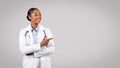 Positive professional millennial black lady doctor point finger to free space