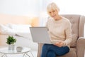 Positive progressive pensioner using a modern laptop and feeling happy