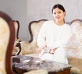 Relaxed young brunette sitting on soft antique sofa at home