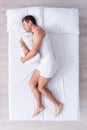 Positive and relaxed young man sleeping on bed Royalty Free Stock Photo