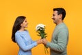 Positive retired caucasian husband give bouquet of flowers to lady, enjoy birthday