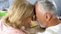 Positive retired couple nuzzling, man and woman affection, old age love, support